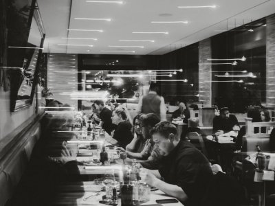 Schwarz-Weiß Foto vom Innenraum des Restaurants mit Gästen